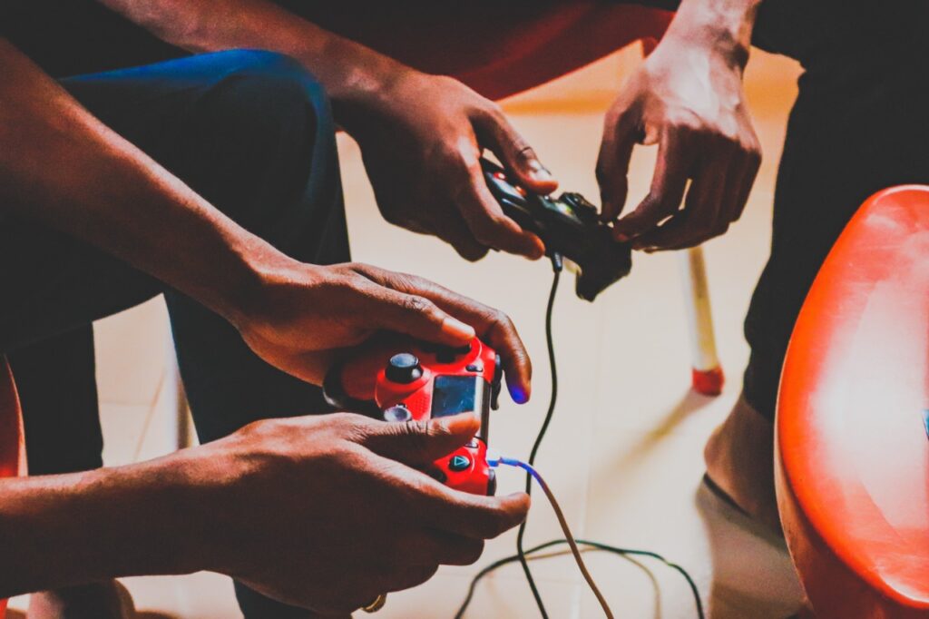 Detalhe de mãos segurando joysticks de videogame